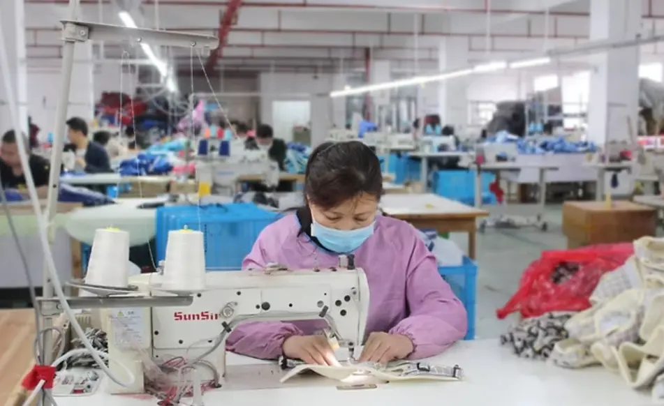 Skilled operator sewing custom dog walking gear during in-process production